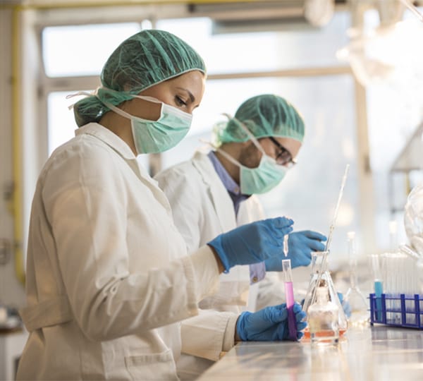 Young chemists working in a lab with protective clothing