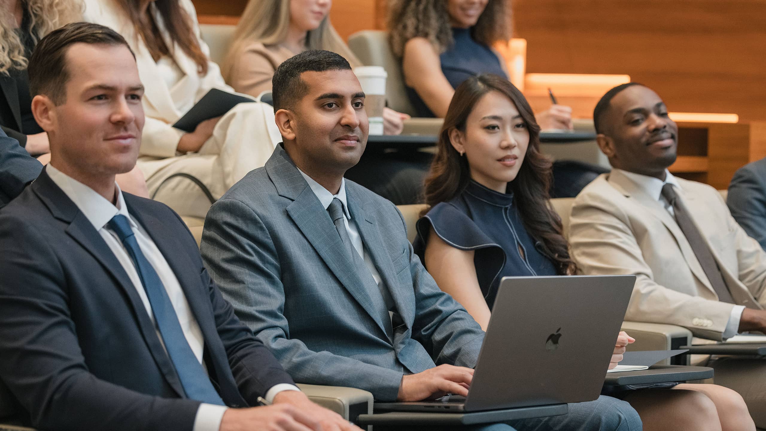 2 people sitting at conference table, 1 person reading pamphlet